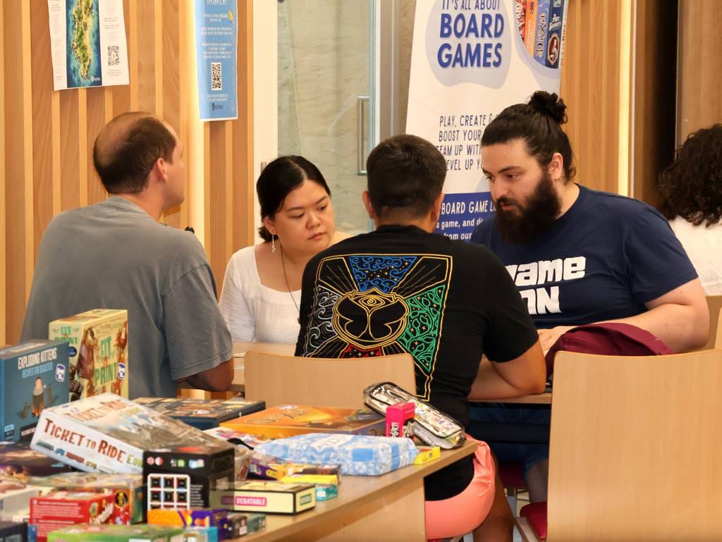 GameOn PlayQuest participant explaining a boardgame to event attendees