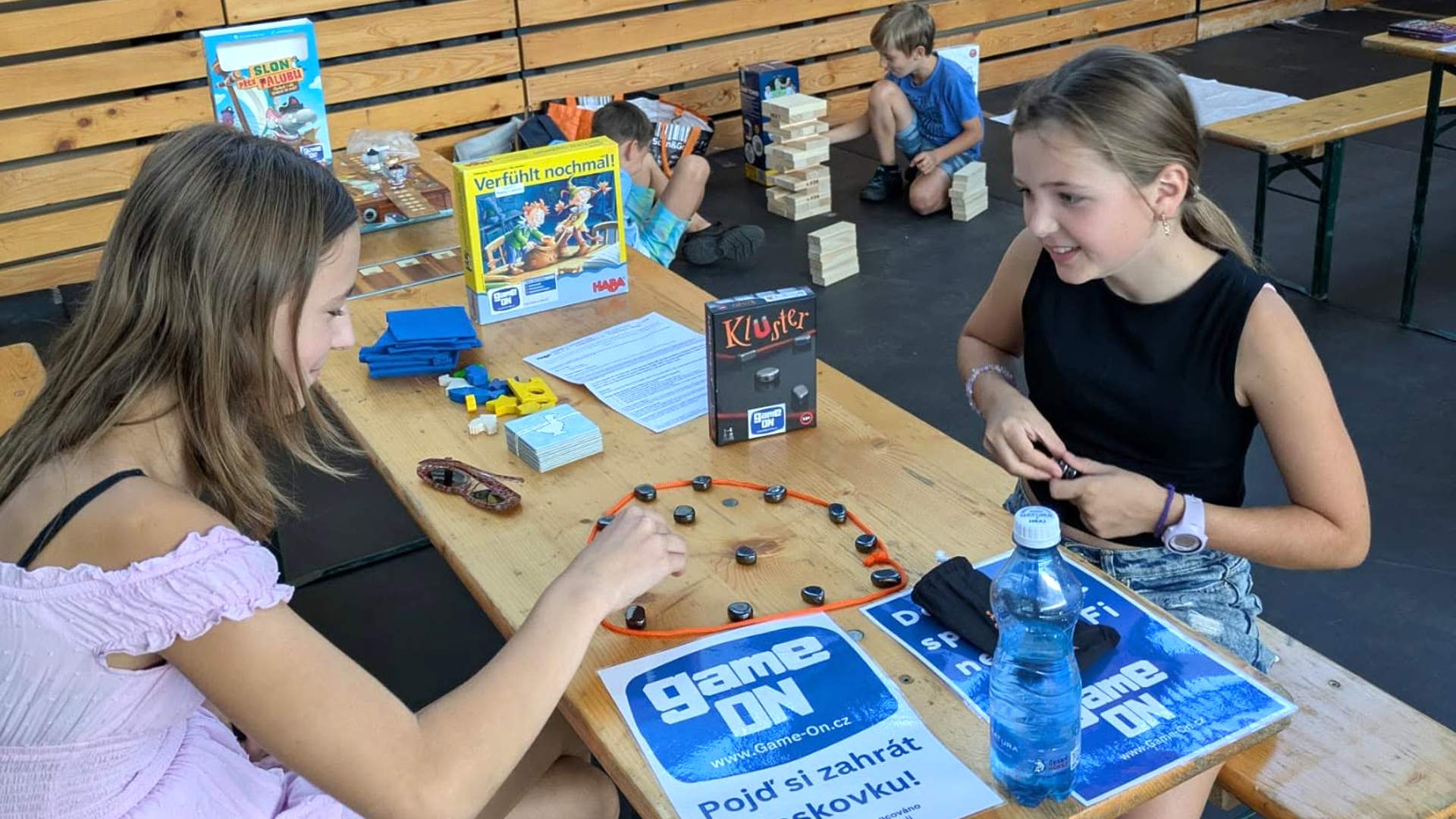 Young people playing a board game at a GameON Czechia activity with Game On project materials on the table.
