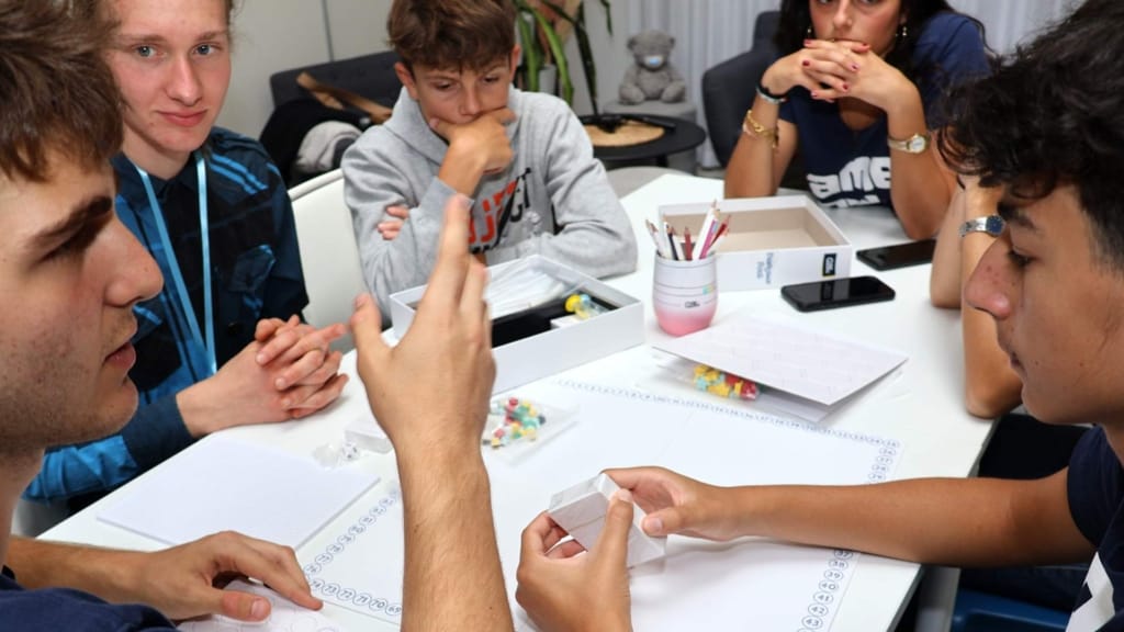 PlayQuest participants developing and discussing a board game prototype during a creative workshop in Prague
