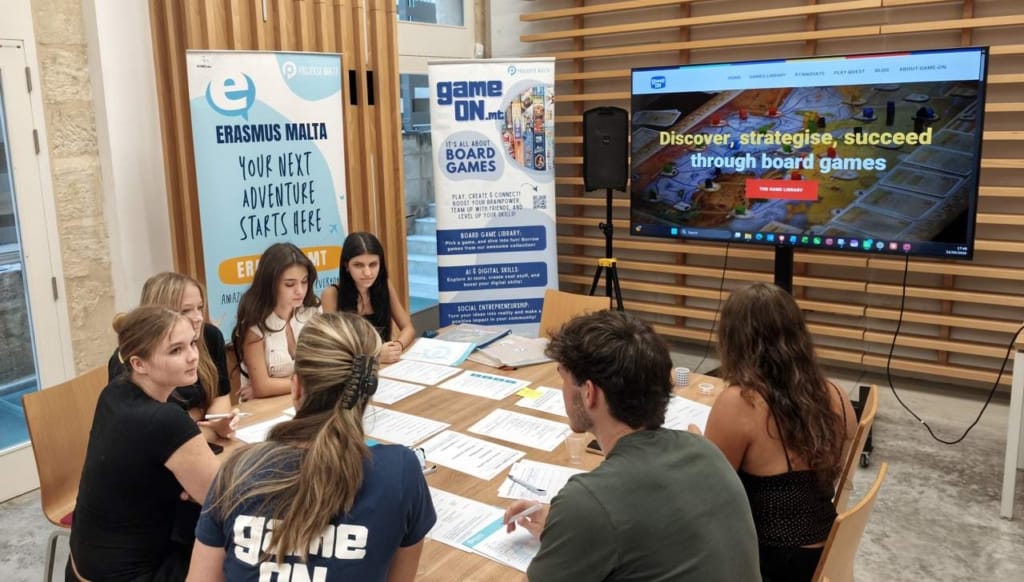 Young people discussing ideas and working with game design materials during the development of The Island at a Projekta event.