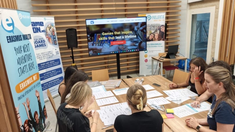 Young people working together around a table during a GAME ON board games and game design event in Malta.