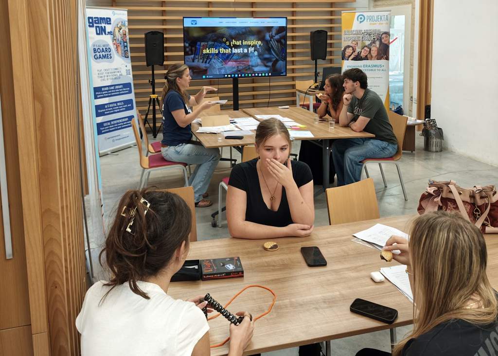 Participants sitting in small groups, playing games and sharing ideas during a GAME ON activity in Malta.